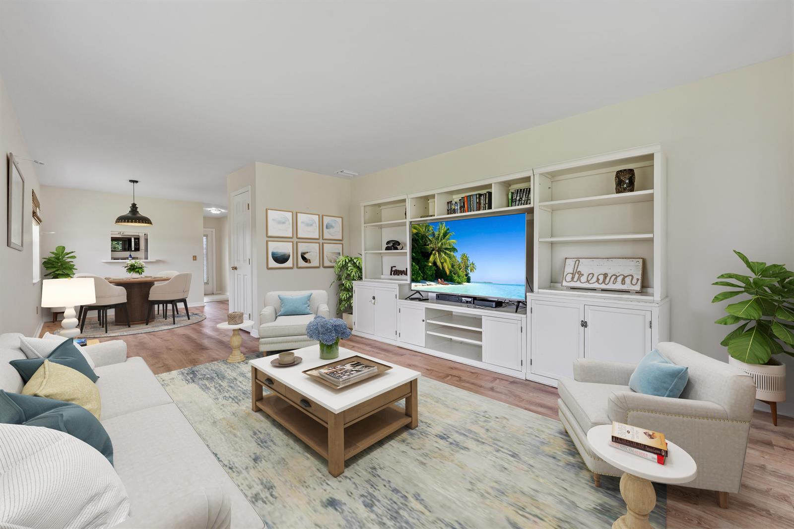 A living room features a large white entertainment center, a coffee table, and two armchairs — 1225 NW 21st Street # 1708, Stuart FL 34994, STUART, FL