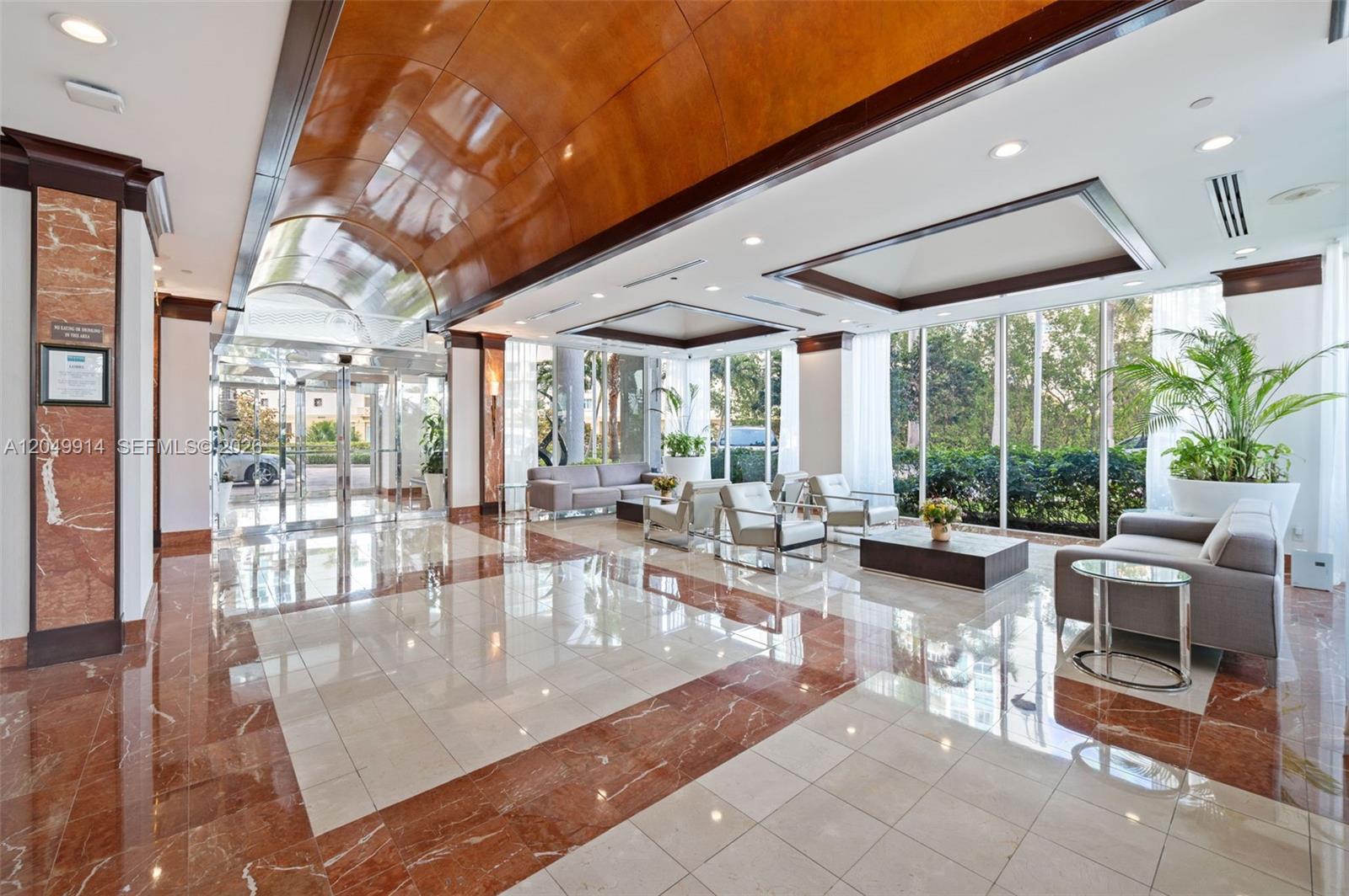 A spacious lobby features a vaulted wood ceiling, marble flooring, and floor-to-ceiling windows — 16400 Collins Ave # 1644, Sunny Isles Beach FL 33160, SUNNY ISLES BEACH, FL