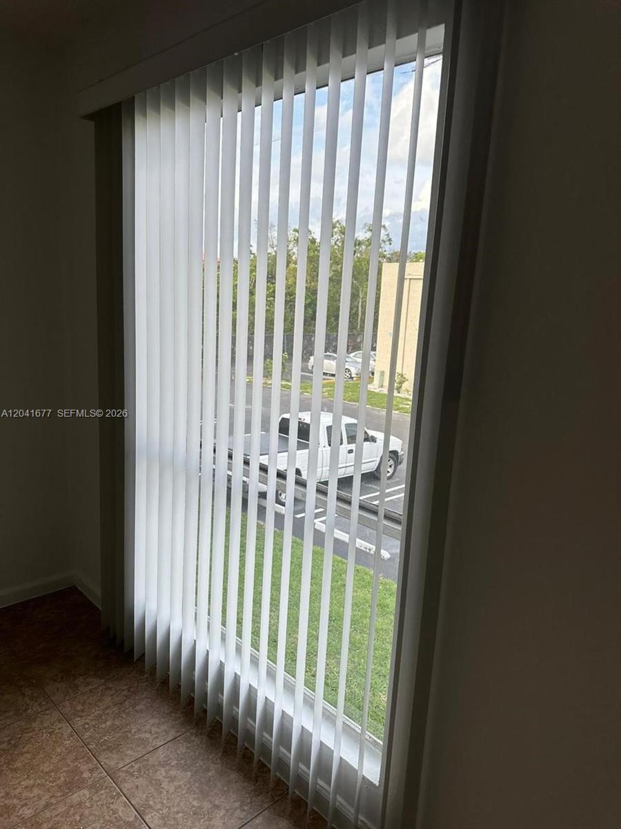 A window with vertical blinds overlooks a parking lot with a white pickup truck — 1500 N Congress Ave # B44, West Palm Beach FL 33401, WEST PALM BEACH, FL