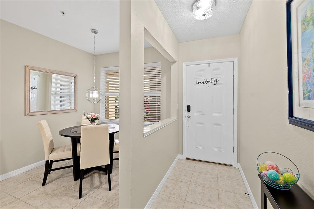 A dining area with a round table is visible next to an entryway with tile flooring — 1000 CANOPY WALK LANE UNIT 1013, PALM COAST, FL
