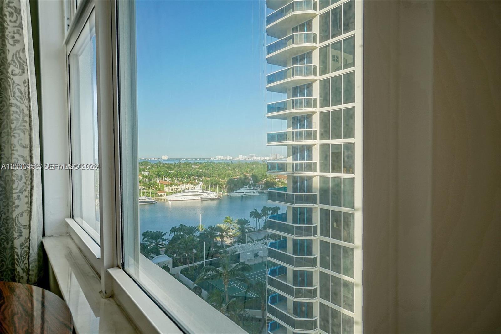 A view of a waterfront area and a neighboring high-rise building from a window — 4747 Collins Ave # 1108, Miami Beach FL 33140, MIAMI BEACH, FL
