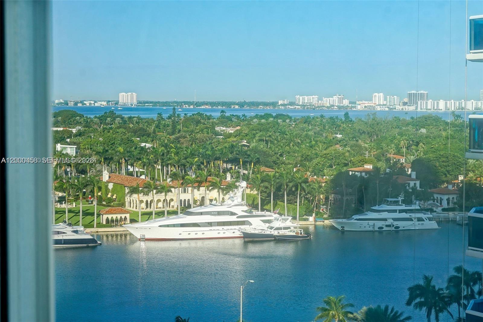 An elevated view shows a waterway with several large yachts docked near waterfront homes — 4747 Collins Ave # 1108, Miami Beach FL 33140, MIAMI BEACH, FL