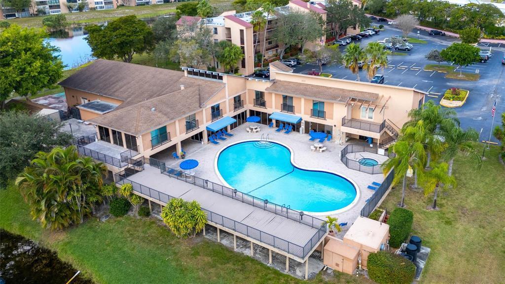 An aerial view of a two-story building with a pool, deck, and parking lot — 480 NW 76th Avenue # 205, Margate FL 33063, MARGATE, FL
