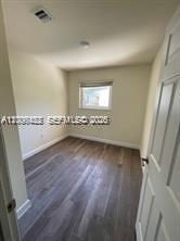 An empty bedroom features light-colored walls, a single window, and dark wood-look flooring — 1680 NW 4th Ave # 8B, Miami FL 33136, MIAMI, FL