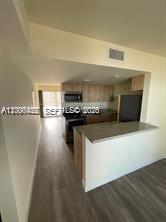 A kitchen with light wood cabinets, granite countertops, and wood-look flooring — 1680 NW 4th Ave # 8B, Miami FL 33136, MIAMI, FL