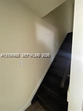 A staircase with dark-colored steps leads upward between two light-colored walls — 1680 NW 4th Ave # 8B, Miami FL 33136, MIAMI, FL
