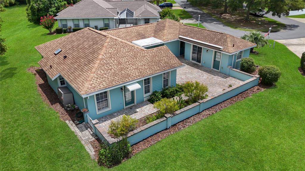An aerial view shows a light blue house with a brown shingled roof and patio — 7221 SW 115TH PLACE, OCALA, FL
