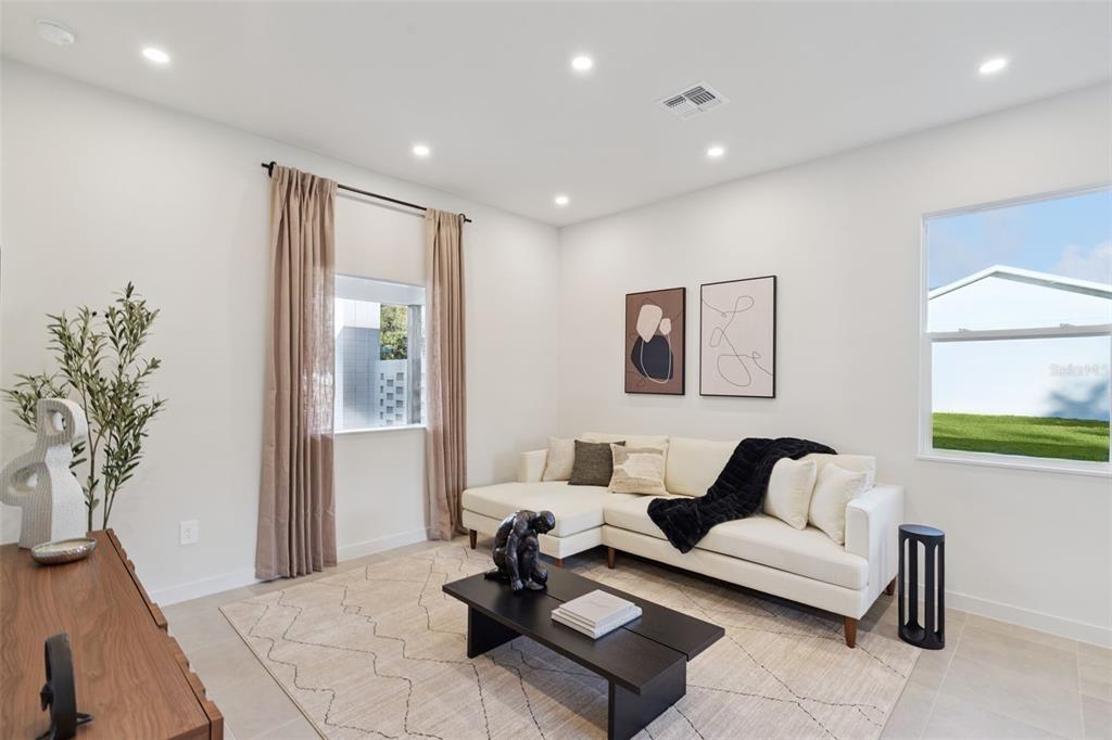 A living room features a white sectional sofa, a black coffee table, and beige curtains — 455 SKYFIELD COURT, LADY LAKE, FL