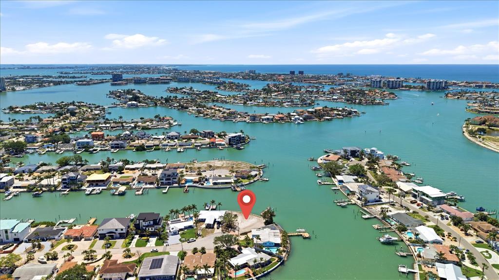 An aerial view shows a waterfront house with a red location pin at sunset — 7998 1ST AVENUE S, ST PETERSBURG, FL