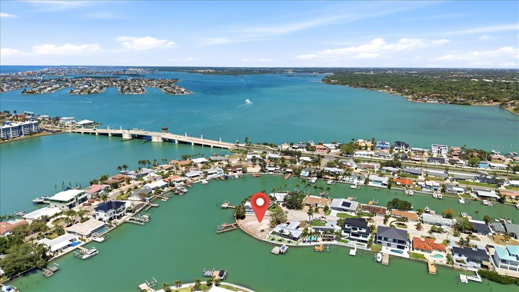 An aerial view of a waterfront property at sunset with a house and empty lot — 7998 1ST AVENUE S, ST PETERSBURG, FL