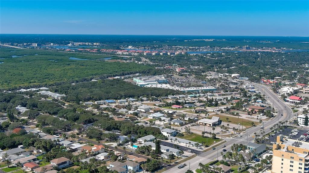 Aerial view of a coastal town featuring residential neighborhoods, commercial buildings, and a nearby bridge — 0 S ATLANTIC AVENUE, NEW SMYRNA BEACH, FL