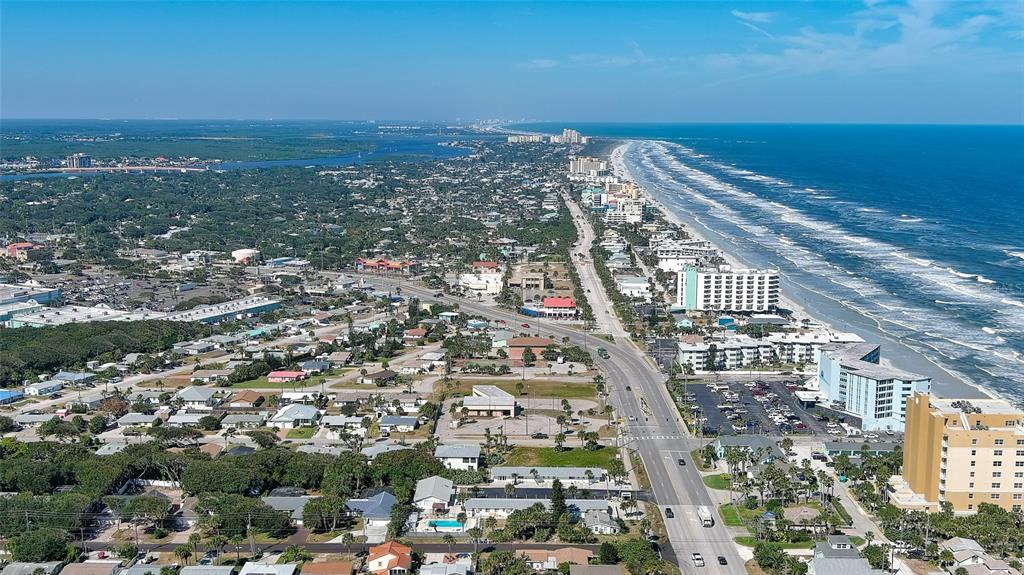 An aerial view shows a coastal town with a long beach, ocean, and highway — 0 S ATLANTIC AVENUE, NEW SMYRNA BEACH, FL