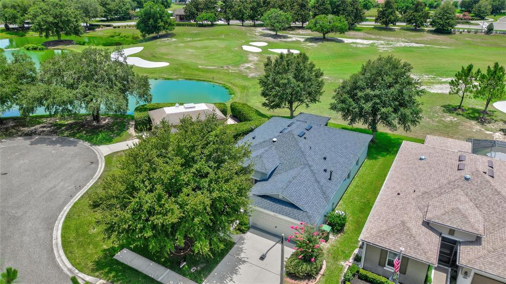 An aerial view shows a house with a gray roof next to a golf course — 4834 INDEPENDENCE TRAIL, LEESBURG, FL