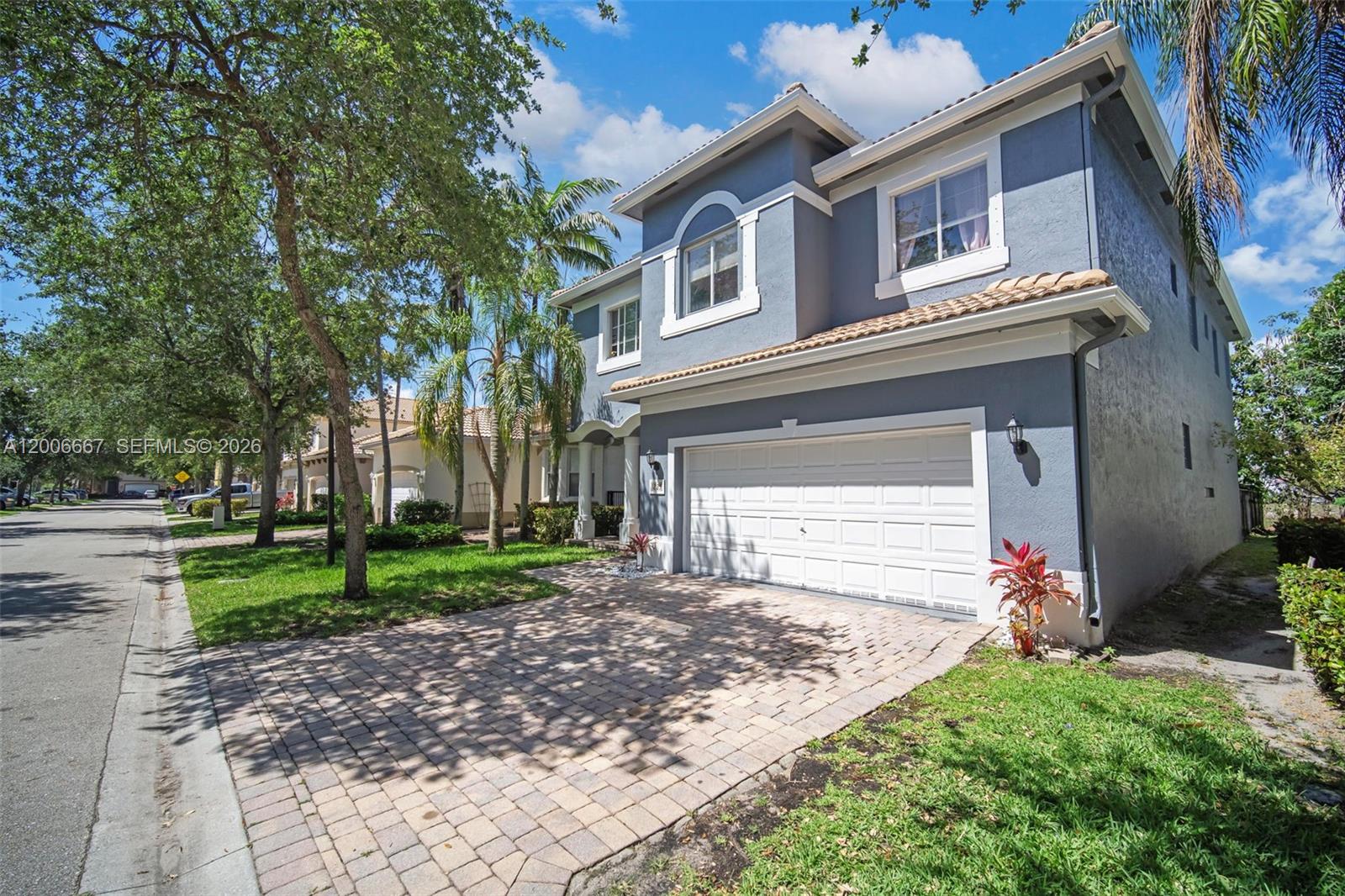 A two-story blue house with a white garage door and a paved driveway — 1225 Rosegate Blvd, Riviera Beach FL 33404, RIVIERA BEACH, FL