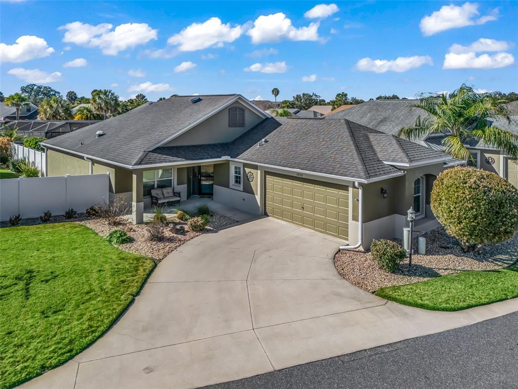 An aerial view of a single-story house with a concrete driveway and a two-car garage — 3698 ROBERTSON WAY, THE VILLAGES, FL