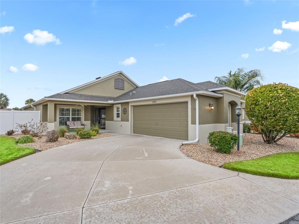 The exterior of a single-story house features a two-car garage and a concrete driveway — 3698 ROBERTSON WAY, THE VILLAGES, FL