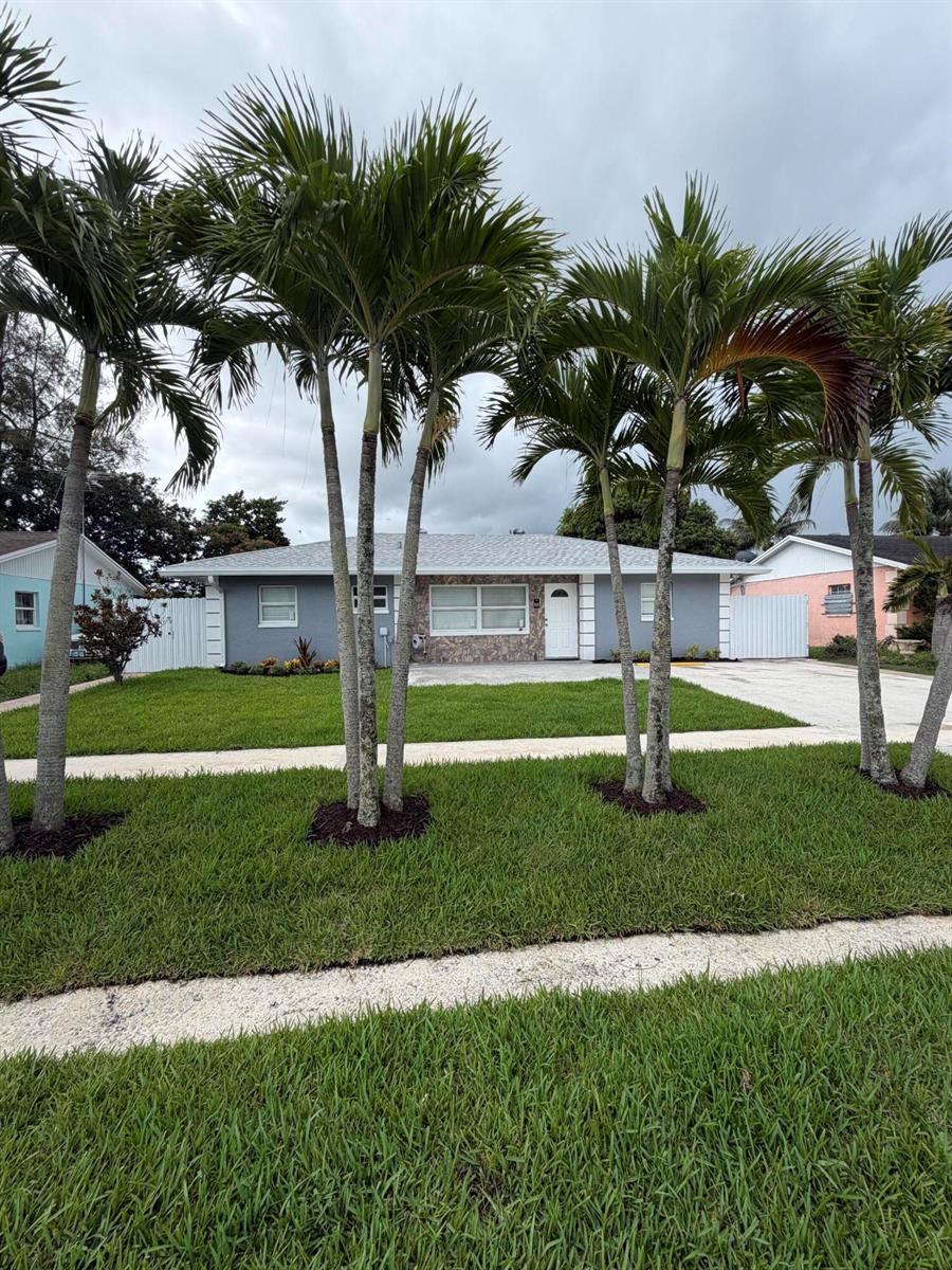 A gray single-story house with a stone facade and palm trees in the front yard — 5612 S 36th Street, FL 33463, FL