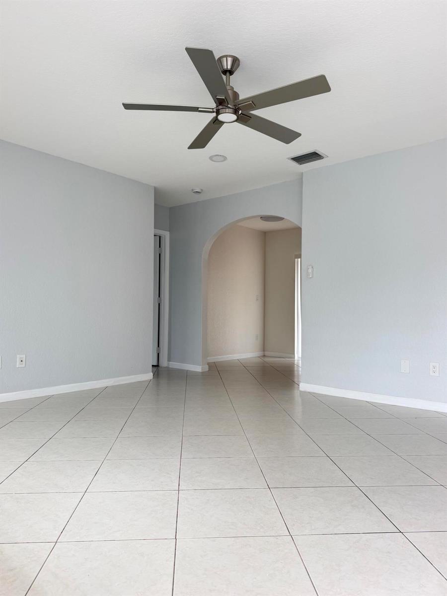 An empty room with light gray walls, tile flooring, and a ceiling fan — 5612 S 36th Street, FL 33463, FL