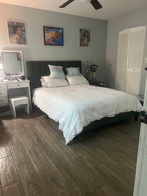 A bedroom features a dark headboard, a white bedspread, a vanity, and wood-look tile flooring — 4016 LAKE BOULEVARD, CLEARWATER, FL