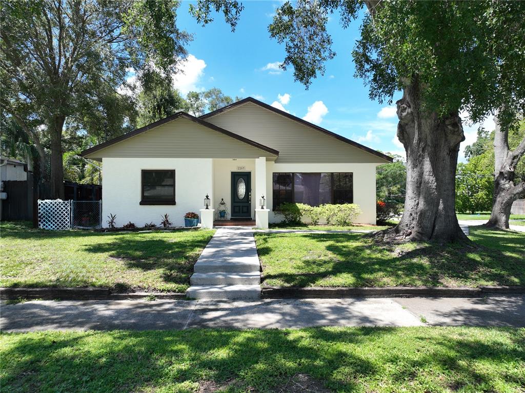 A single-story house with a white stucco facade, tan siding, and a central front entrance — 2207 W OHIO AVENUE, TAMPA, FL