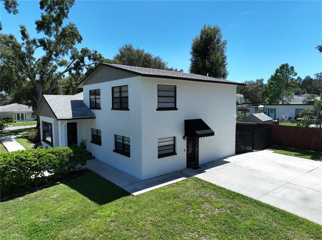 A two-story white house with a gray roof and a concrete driveway — 2207 W OHIO AVENUE, TAMPA, FL