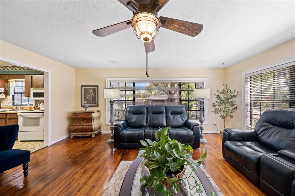 A living room features hardwood floors, two black leather sofas, and a ceiling fan — 2207 W OHIO AVENUE, TAMPA, FL