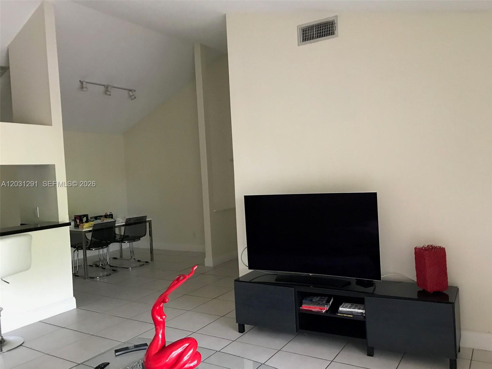 A living room features a flat-screen television on a black stand and tiled flooring — 10610 SW 158th Ct # 303, Miami FL 33196, MIAMI, FL