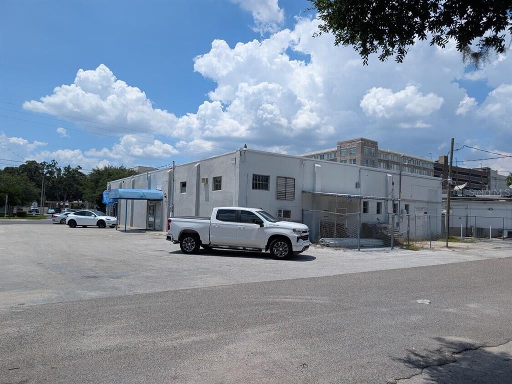 A white commercial building with a parking lot and a white pickup truck — 915 S ORANGE AVENUE, ORLANDO, FL