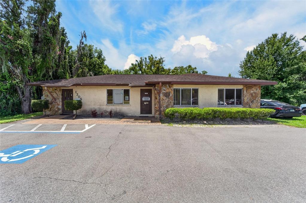 A single-story commercial building with stone accents, two entrance doors, and a paved parking lot — 1205 W BAKER STREET, PLANT CITY, FL