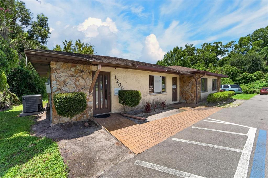 A single-story commercial building with stone accents, a brick walkway, and a paved parking lot — 1205 W BAKER STREET, PLANT CITY, FL