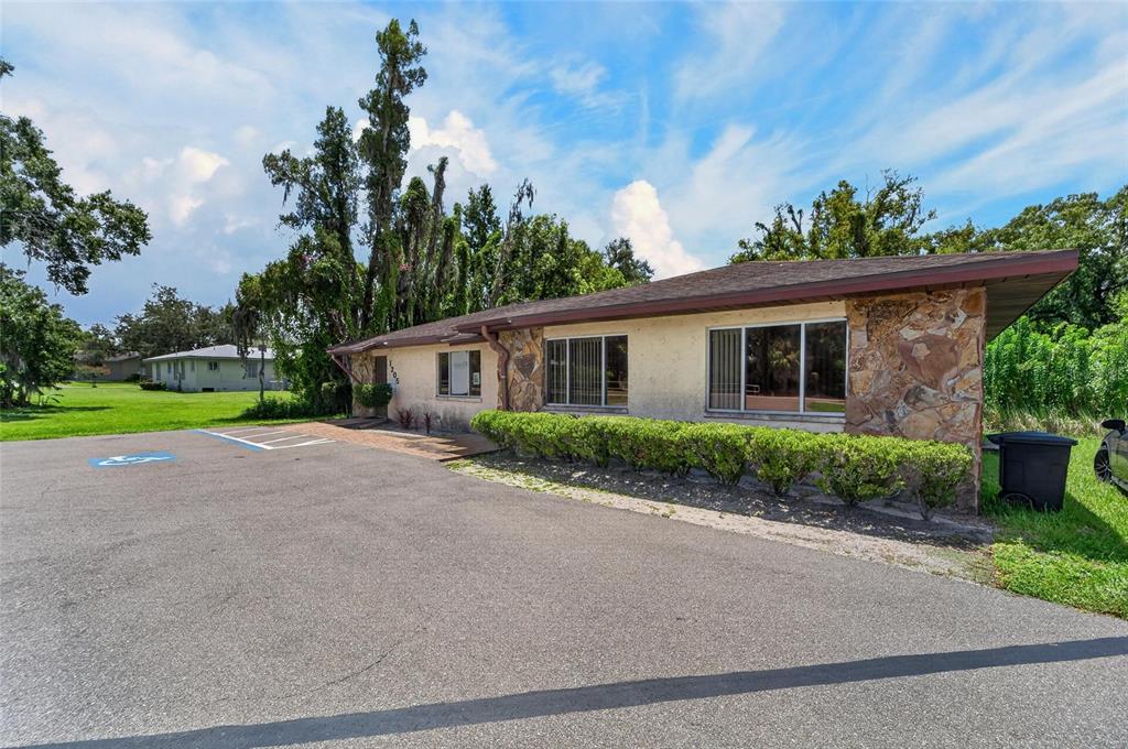 A single-story building with a stone facade, a paved parking lot, and a handicap space — 1205 W BAKER STREET, PLANT CITY, FL