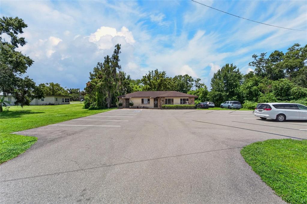 A single-story building with a parking lot in front under a blue sky — 1205 W BAKER STREET, PLANT CITY, FL
