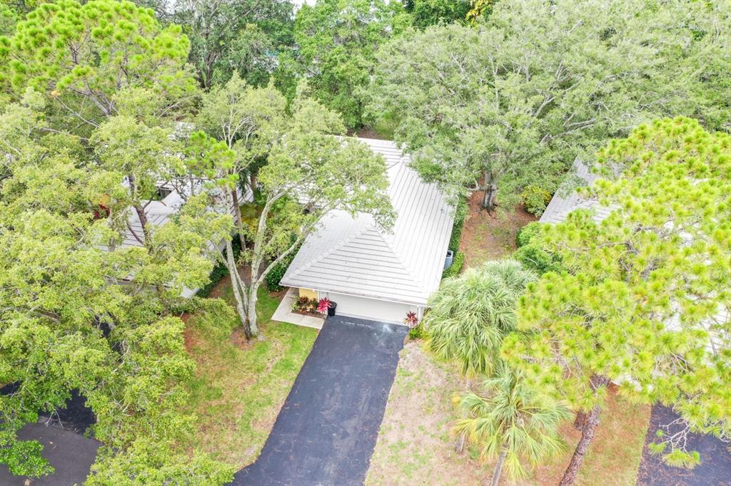 An aerial view shows a house with a light-colored roof, driveway, and surrounding trees — 243 SOUTHAMPTON LANE UNIT 273, VENICE, FL