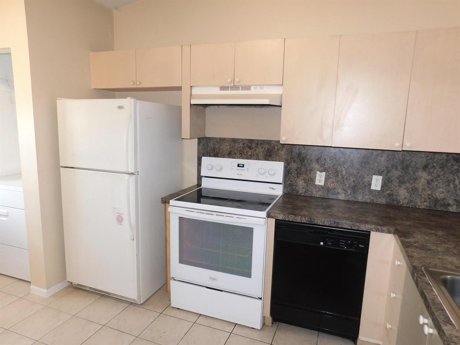 A kitchen features light wood cabinets, a white refrigerator, a white stove, and a dishwasher — 3800 N Jog Road # 204, West Palm Beach FL 33411, WEST PALM BEACH, FL