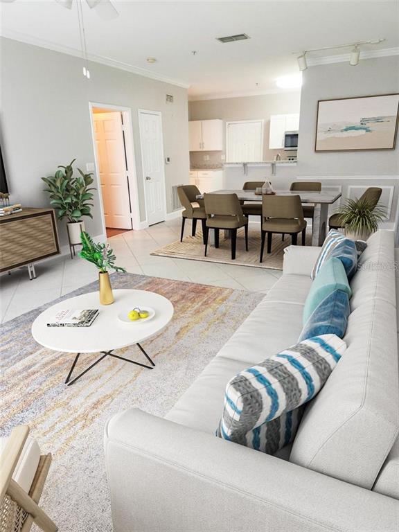 A living room and dining area feature light-colored furniture, a patterned rug, and tile flooring — 4307 BAYSIDE VILLAGE DRIVE UNIT 103, TAMPA, FL