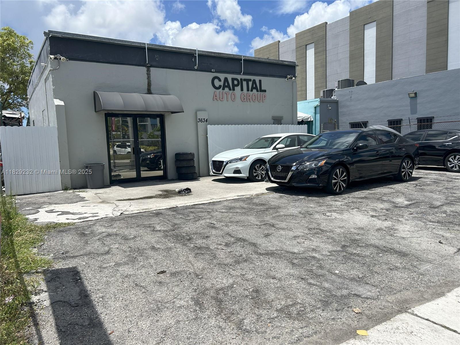 The exterior of a commercial building features a sign for Capital Auto Group and parked cars — 3634 NW 36th St, Miami FL 33142, MIAMI, FL