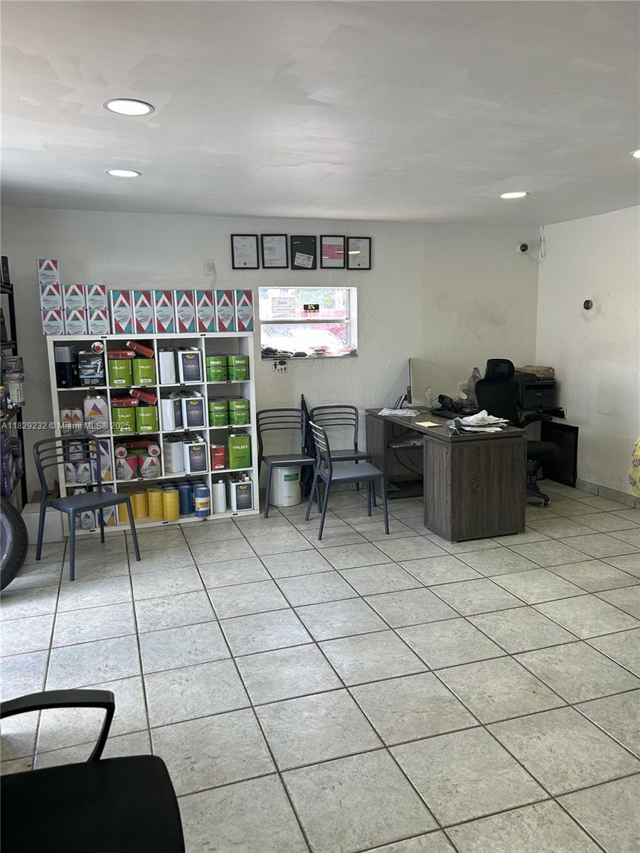 An office space features a white shelving unit filled with paint cans, a desk, and chairs — 3634 NW 36th St, Miami FL 33142, MIAMI, FL