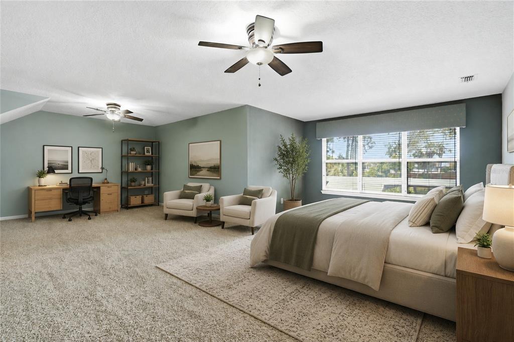 A spacious bedroom features a bed, two armchairs, a desk, and a ceiling fan — 1413 COURSE VIEW, ORANGE PARK, FL