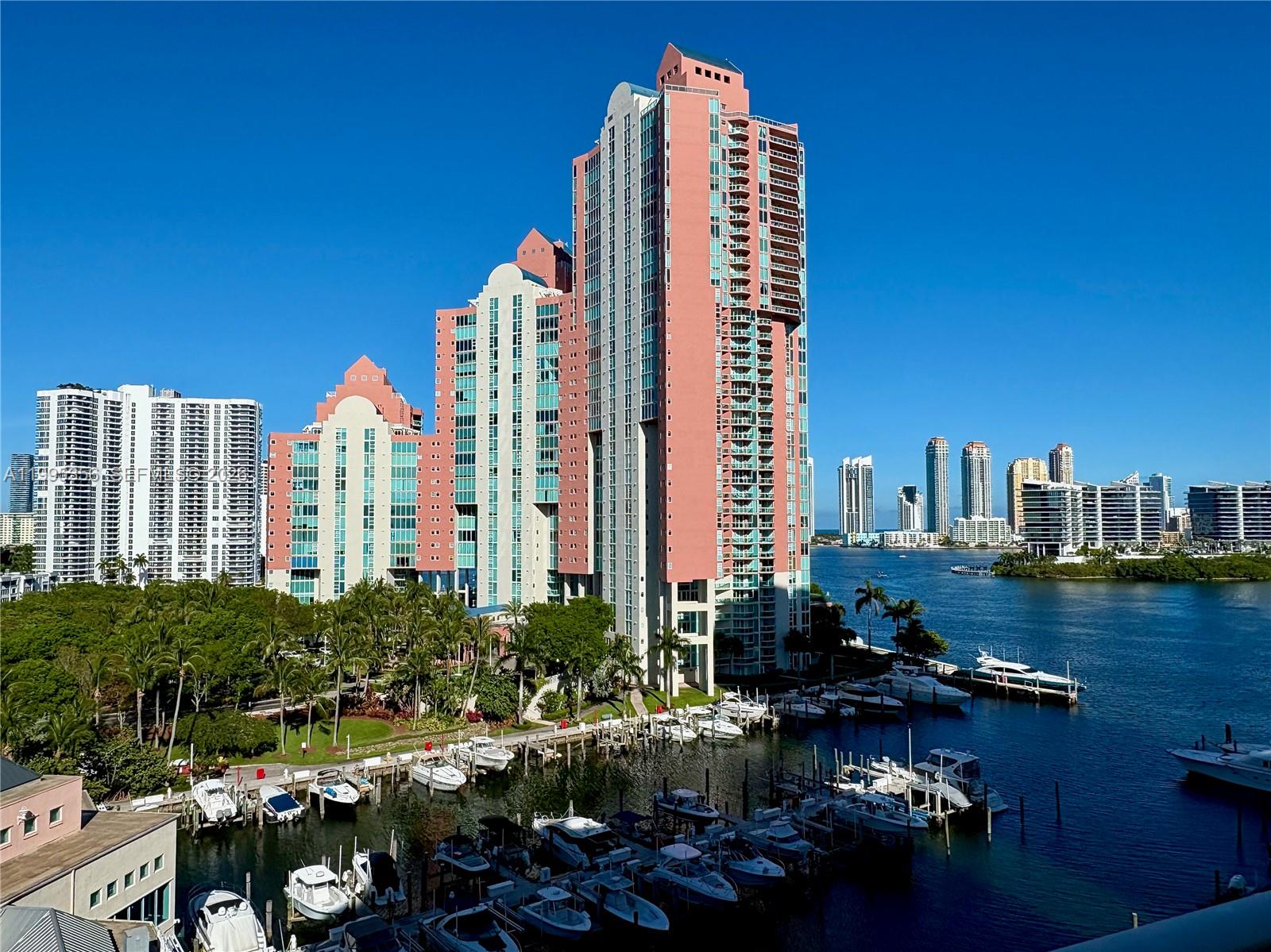 A tall pink residential building overlooks a marina filled with boats on a sunny day — 3340 NE 190th St # 1004, Aventura FL 33180, AVENTURA, FL