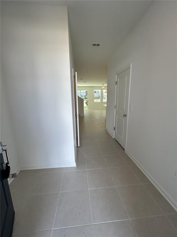 A tiled entryway leads into a hallway with a white door and an open living area — 3111 KURTZ TER, DAVENPORT, FL