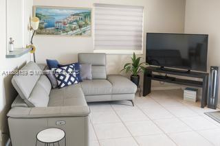 A living room features a gray sectional sofa, a television on a stand, and artwork — 255 Central Blvd, Miami FL 33144, MIAMI, FL