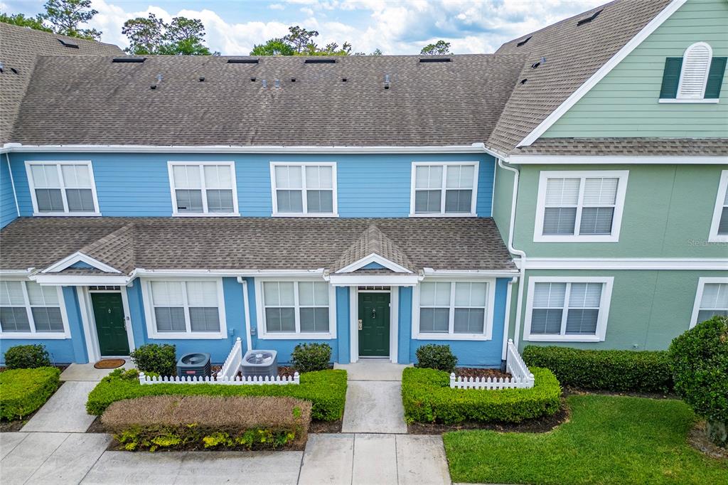 An aerial view of a two-story townhouse complex with blue and green siding — 4017 VENETIAN BAY DRIVE UNIT 103, KISSIMMEE, FL