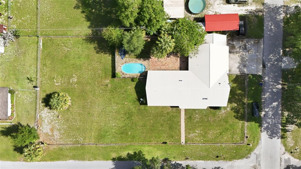 An aerial view shows a house with a white roof, a pool, and a large yard — 22526 SE 62ND AVENUE, HAWTHORNE, FL