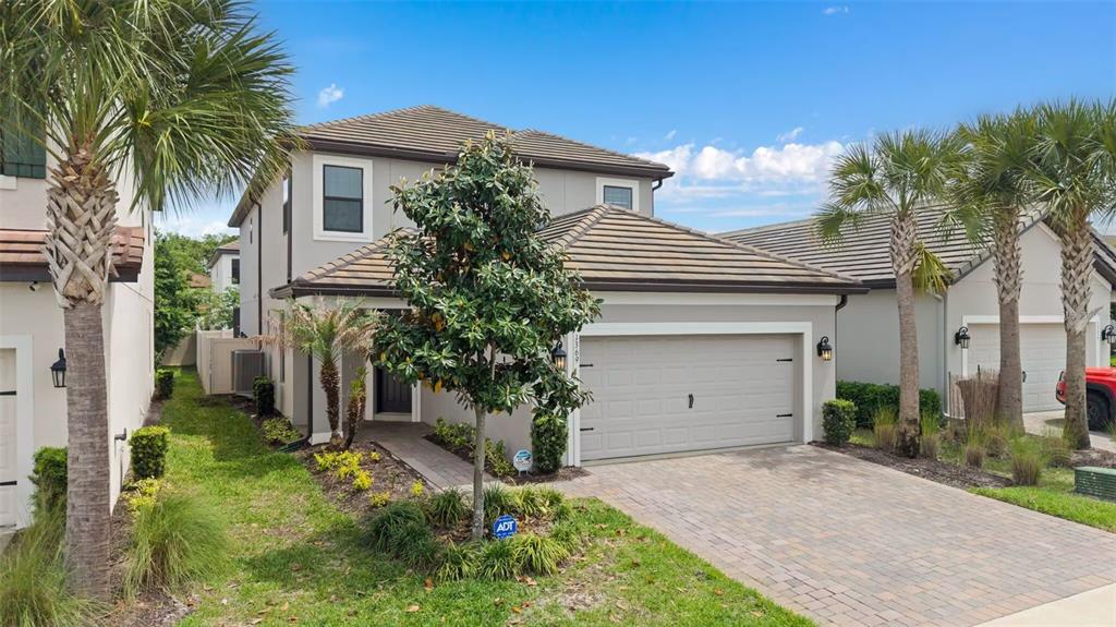 A two-story suburban house with a paved driveway, a two-car garage, and palm trees — 1369 BLUE STEM LANE, WINTER PARK, FL