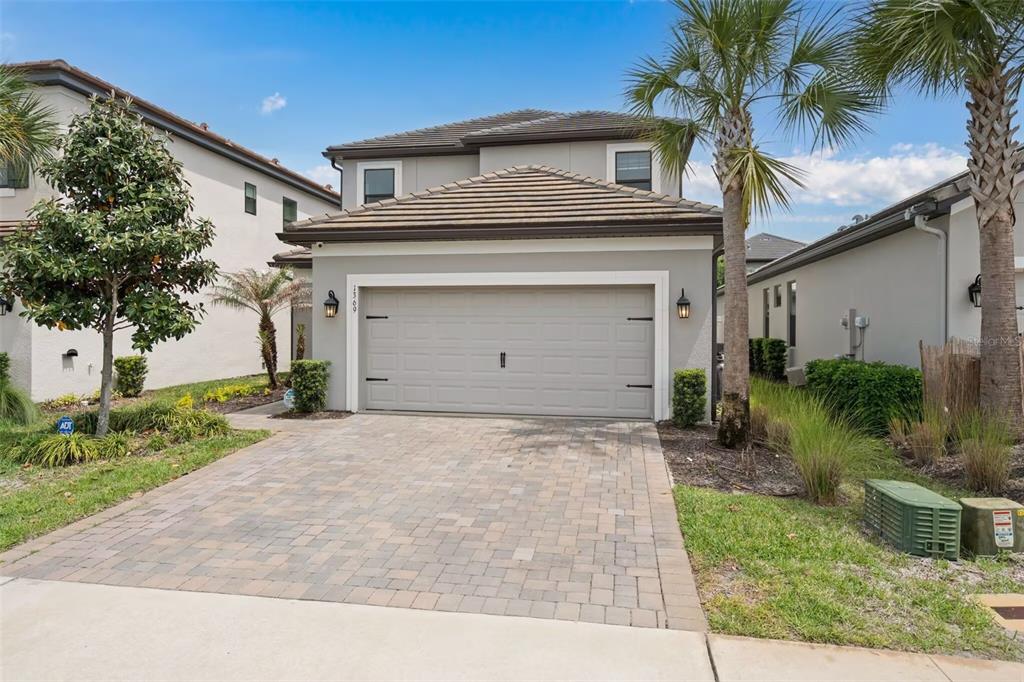 A two-story house with a gray exterior, a two-car garage, and a paved driveway — 1369 BLUE STEM LANE, WINTER PARK, FL