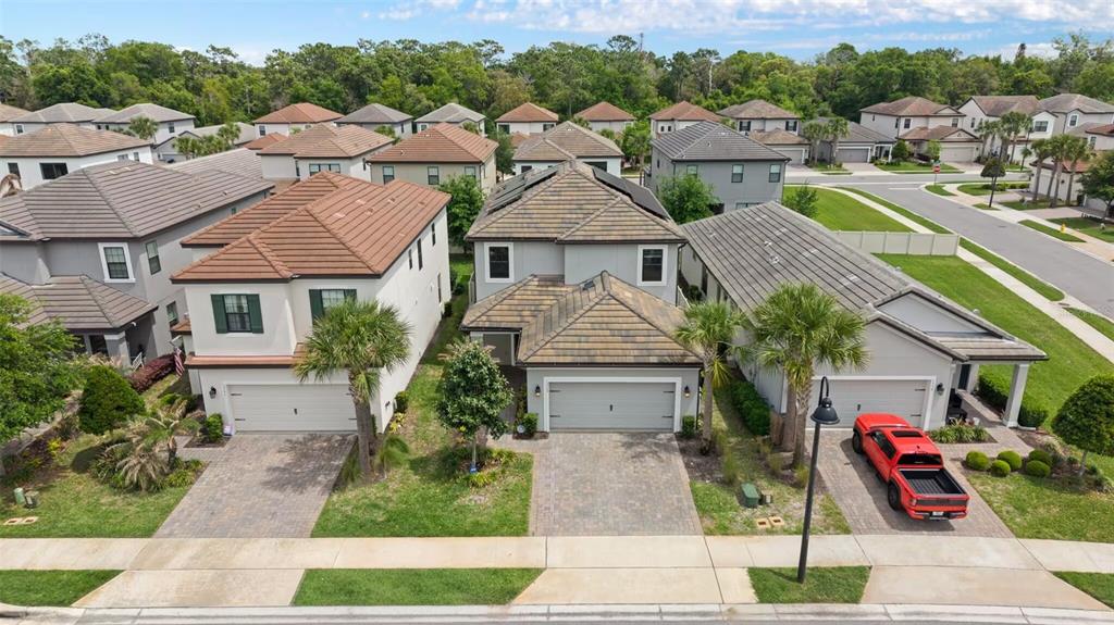 An aerial view shows three suburban houses with tiled roofs and paved driveways — 1369 BLUE STEM LANE, WINTER PARK, FL