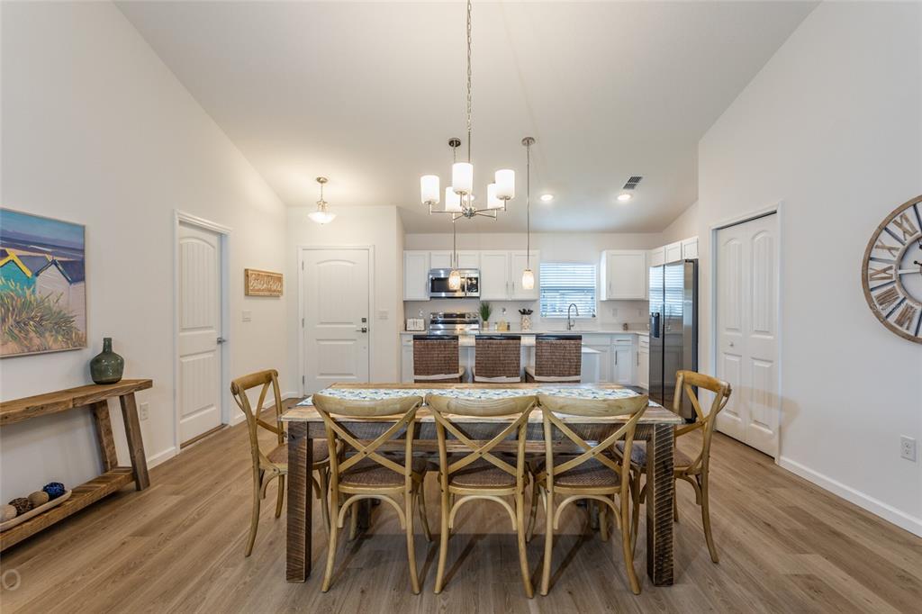 A dining area with a wooden table and chairs sits in front of an open kitchen — 43 FREELAND, PALM COAST, FL
