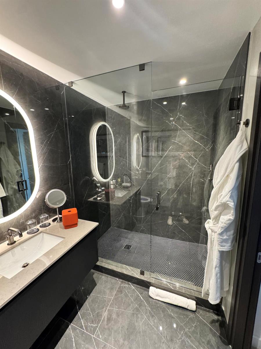 A modern bathroom features a glass-enclosed shower, dark marble tile, and a floating vanity — 20 NE 11th Street # 4805, Miami FL 33132, MIAMI, FL