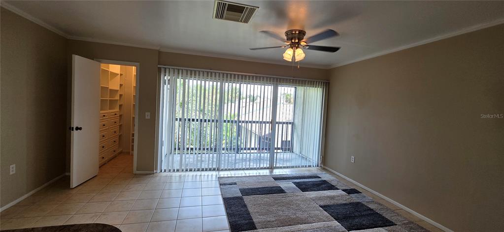 A room with tile flooring, a ceiling fan, a large area rug, and a walk-in closet — 3814 N LAKE DRIVE UNIT 70, TAMPA, FL