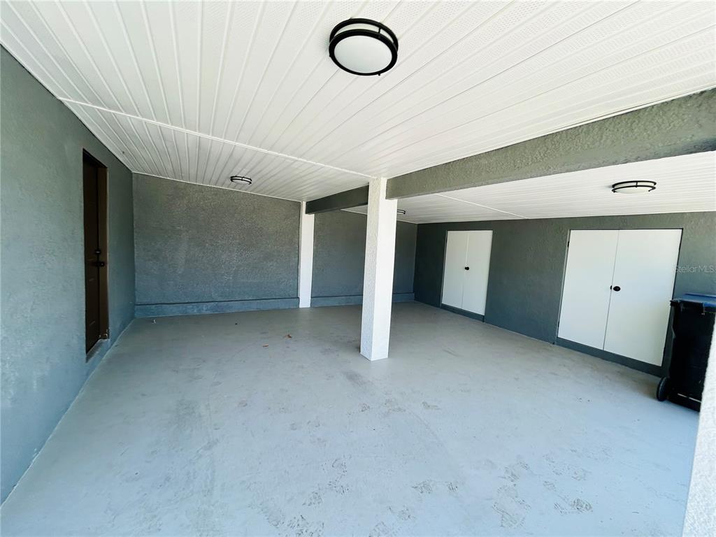 A covered carport with gray walls, a white ceiling, and two storage closets — 6603 COCOS DRIVE, ORLANDO, FL